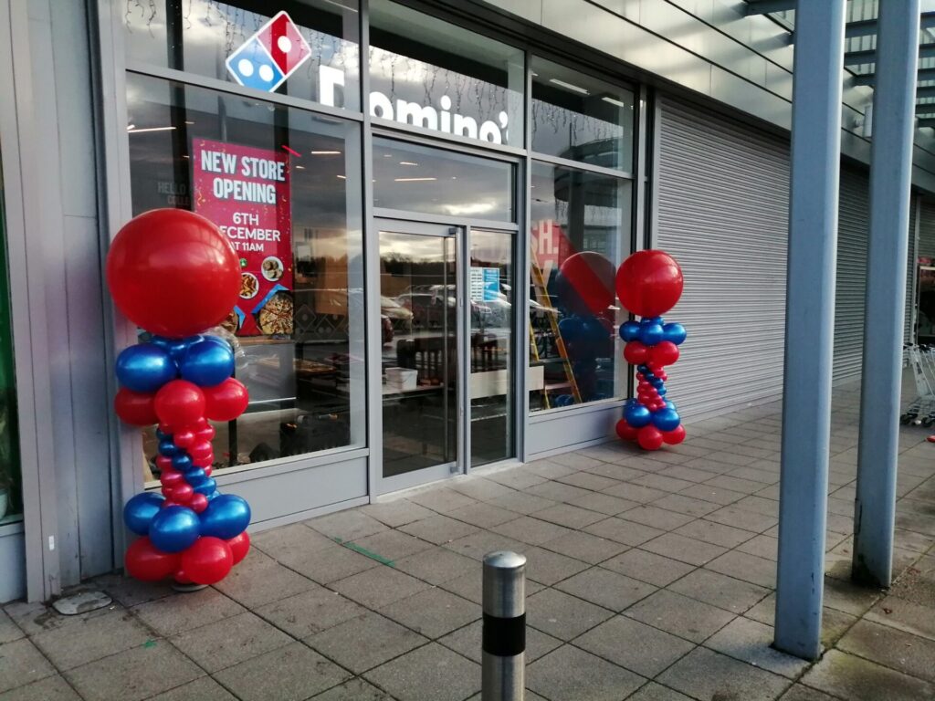 Red and blue balloon pillars outside Domino's