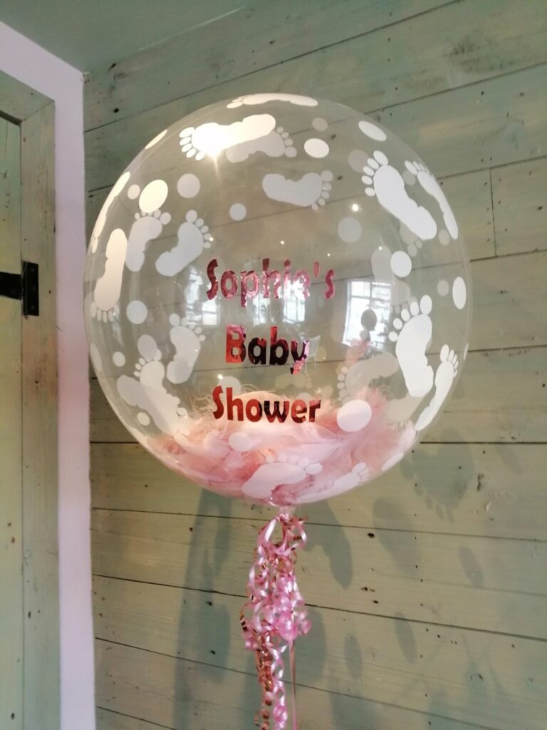 Large baby shower bubble balloon with pink feathers