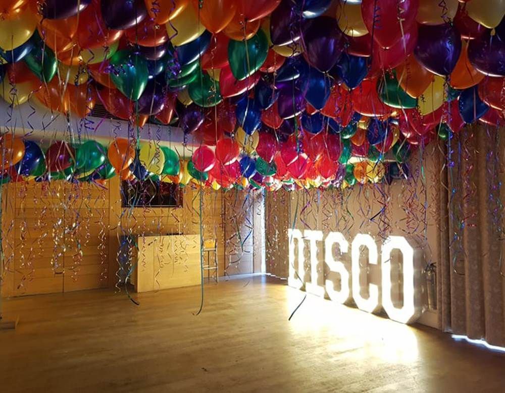 Multi-coloured ceiling balloons in a function room in Liverpool